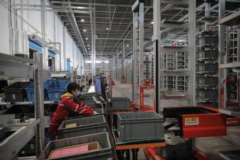 Fotografía de archivo de un trabajador en una unidad de transporte de contenedores en Pekín (China).