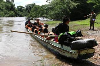 Migrantes llegan en canoa por el río Tuquesa desde el poblado de Bajo Chiquito hasta el centro de recepción de Lajas Blancas, el 28 de junio de 2024, en el Darién.