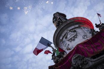 Fuegos artificiales se encienden mientras la gente se reúne frente a la estatua “Le Monument à la Republique” el pasado domingo después de las elecciones.