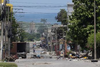 Un hombre cruza corriendo una calle cercana al Palacio Nacional, zona de frecuentes enfrentamientos entre la policía y las bandas armadas, este sábado, en Puerto Príncipe