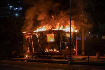 Fotografía de un módulo de la Policía Nacional Bolivariana (PNB) incendiado durante las protestas por los resultados de las elecciones presidenciales este lunes, en la autopista Prados del Este, en Caracas.