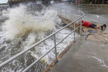 Un visitante desafía el fuerte oleaje, la marejada ciclónica y los fuertes vientos del huracán Helene para tomar fotografías en el centro de Cedar Key, Florida, EE. UU., El 26 de septiembre de 2024.