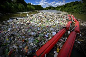 La basura es arrastrada por la corriente del río San Juan hasta una barrera.