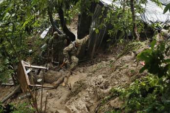 Soldados recorren la zona donde un derrumbe destrozó una vivienda este martes, en Ciudad Delgado (El Salvador).