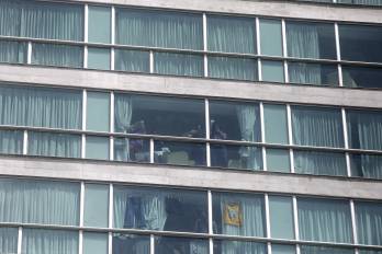 Migrantes hacen señas desde una ventana del hotel Decápolis este martes en Ciudad de Panamá, donde se mantienen tras ser deportados de EE.UU.