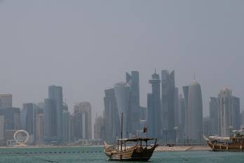 A picture shows a moored dhow with the Doha skyline in the background on a hot and humid summer day on August 6, 2025. (Photo by Karim JAAFAR / AFP)