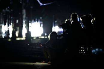 Personas esperan en una calle sin luz este sábado, en La Habana, Cuba.