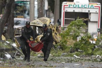 Integrantes de la Policía Nacional trasladan un cilindro tras una explosión en inmediaciones de la Escuela Militar de Aviación Marco Fidel Suárez este jueves, en Cali (Colombia). Al menos cinco personas murieron y 36 resultaron heridas por un atentado perpetrado con un camión bomba. EFE/ Ernesto Guzmán Jr