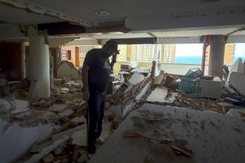 Una persona habla por teléfono en una edificación destruida por los terremotos en Catia La Mar (Venezuela).