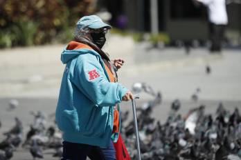 AME1247. SAN SALVADOR (EL SALVADOR), 02/02/2026.- Una mujer camina por el centro histórico este lunes, en San Salvador (El Salvador). Centroamérica afronta una extraordinaria ola de frío que golpea principalmente a Guatemala, Honduras y El Salvador, con temperaturas históricas de hasta -2 grados en algunas zonas montañosas, con la excepción de Panamá. EFE/Rodrigo Sura