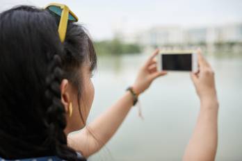 Young woman taking photo of the city, selective focus