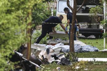 Profesionales del Instituto de Medicina Legal cubren los cuerpos de las personas fallecidas hoy en un accidente de avioneta, en Jaboticabal, estado de Sao Paulo (Brasil). EFE/ Luciano Claudino