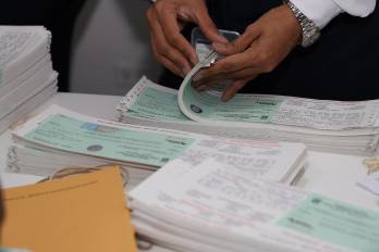 Auditores de la Contraloría resguardan los cheques que entregarán a los funcionarios de la Asamblea Nacional.