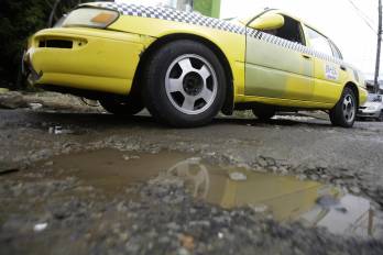 Fotografía de un vehículo pasando por una vía con huecos, en Ciudad de Panamá (Panamá). EFE/ Carlos Lemos