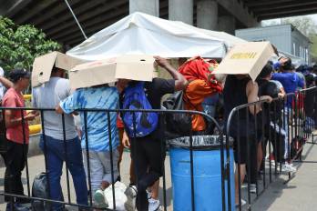 Migrantes permanecen en un punto de revisión del Instituto Nacional de Migración para entregarse y ser trasladados a Tuxtla Gutiérrez, en Chiapas.