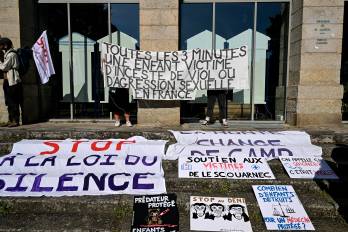 Manifestantes sostienen una pancarta que dice “Cada 3 minutos, un niño es víctima de incesto, violación o agresión sexual en Francia” durante una manifestación en apoyo a las víctimas del excirujano.