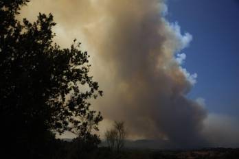 Columna de humo producida por el incendio que se mantiene activo en la localidad madrileña de Pelayos de la Presa, este viernes.