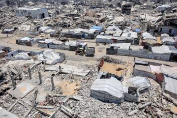 En la fotografía, tomada el 6 de julio de 2026, se observan tiendas de campaña y refugios junto a los escombros de edificios derrumbados en un campamento para desplazados por la guerra en el barrio de Sheikh Radwan, en la ciudad de Gaza.