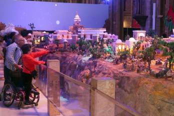 Fotografía del 11 de diciembre de 2025 que muestra personas observando el pesebre más grande de Suramérica exhibido en la Basílica del Voto Nacional en Quito (Ecuador).