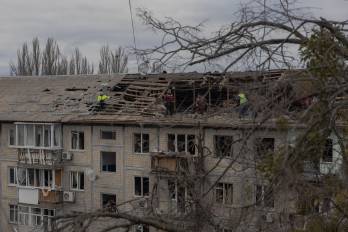 Trabajadores retiran escombros del techo de un edificio residencial gravemente dañado tras un ataque con drones en Kyiv, el 23 de diciembre de 2025, en medio de la invasión rusa de Ucrania.