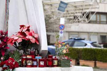 Flores y velas depositadas al pie de la estatua de Juan Pablo II ante la entrada del Hospital Universitario Gemelli de Roma, donde permanece ingresado el papa Francisco.