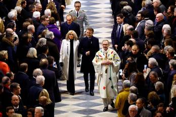 El presidente francés, Emmanuel Macron (D), y su esposa, Brigitte, llegan para asistir a la Misa inaugural, con la consagración del altar mayor, en la Catedral de Notre-Dame.