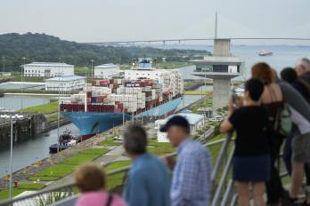 Turistas observan al carguero danés Lars Maersk navegando por las esclusas de Agua Clara del Canal, en la ciudad de Colón.
