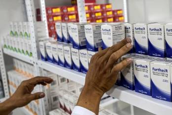 Un hombre coloca medicamentos en una clínica recién inaugurada para pacientes con VIH/SIDA en Cali, Colombia.