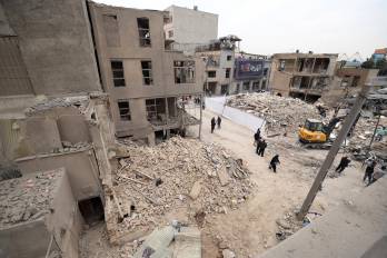 Iraníes caminan entre edificios residenciales dañados en el sur de Teherán, Irán, 15 de marzo de 2026.