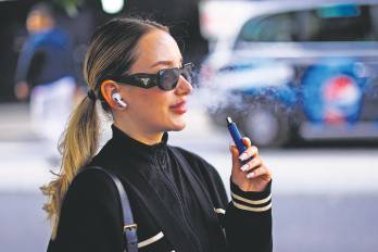Una mujer utiliza un vapeador