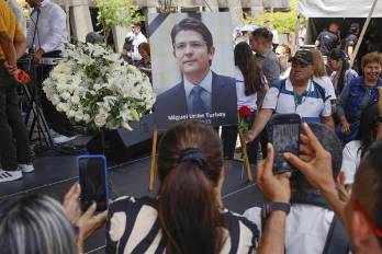 Personas toman fotografías a una imágen del fallecido senador y precandidato de Colombia Miguel Uribe Turbay, durante un homenaje este martes.