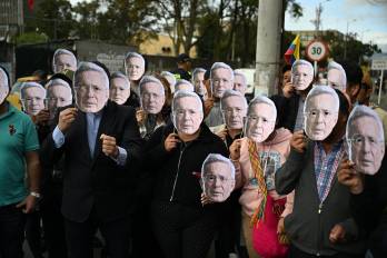 Partidarios del expresidente colombiano Álvaro Uribe portan máscaras con su rostro mientras esperan el veredicto de su juicio frente al Complejo Judicial de Paloquemao en Bogotá el 28 de julio de 2025.