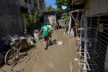 Hombres caminan a través del lodo después de que graves inundaciones afectaran la ciudad de Álamo, en el estado de Veracruz, México, el 13 de octubre de 2025.
