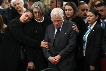 Miguel Uribe Londoño (centro), padre del asesinado precandidato presidencial colombiano Miguel Uribe, Turbay observa el féretro de su hijo durante el sepelio en el cementerio central de Bogotá este 13 de agosto.