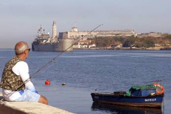 Una persona observa un barco de ayuda humanitaria procedente de México este jueves, en el puerto de La Habana (Cuba).