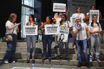 Familiares de presos políticos sostienen carteles durante una vigilia frente a El Helicoide este viernes, en Caracas.