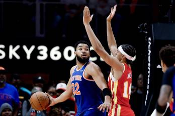 El pívot de los New York Knicks, Karl-Anthony Towns recibe la marca del pívot de los Atlanta Hawks, Asa Newell, durante el juego de este sábado en Atlanta (Georgia).