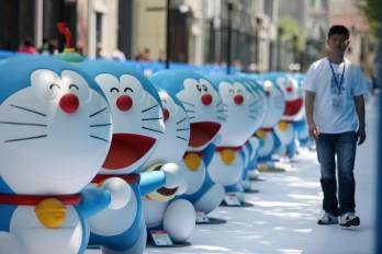 Imagen de archivo donde un empleado chino pasa junto a maquetas de Doraemon, un famoso personaje de dibujos animados japonés, en una exposición en Shanghái, China.