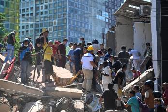 Personas buscan sobrevivientes entre los escombros de un edificio derrumbado tras un terremoto en Cali, Colombia, el 10 de agosto de 2026.
