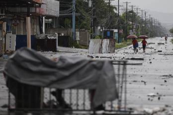 Personas caminan por una via afectada por las manifestaciones este sábado, en Changuinola en Bocas del Toro (Panamá).