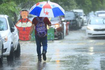Panameño camina en medio de las fuertes lluvias en ciudad de Panamá.