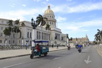 Un triciclo y varias motocicletas eléctricas circulan frente al Capitolio este martes en La Habana (Cuba).