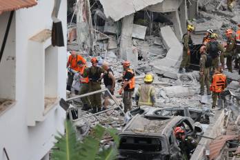 Equipos de emergencias trabajan en el lugar donde impactó un misil lanzado desde Irán cerca de la ciudad israelí de Tel Aviv.