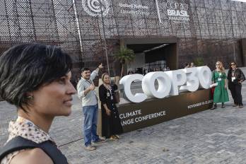 Personas se toman una fotografía junto a un cartel de la COP30 en Belém (Brasil.