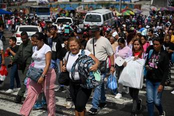 People cross Bolivar Avenue, one of the main thoroughfares in Caracas, on December 23, 2025.