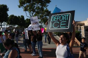 Una mujer sostiene un cartel que dice “Deporten a ICE” mientras la gente protesta pacíficamente tras las denuncias sociales sobre las operaciones federales de inmigración del Servicio de Inmigración y Control de Aduanas (ICE) en Lawndale, California.