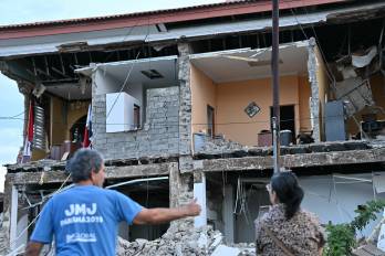 Una pareja observa el edificio de la Gobernación de Penonomé, que colapsó tras un terremoto de magnitud 7.6 que sacudió al país, en Penonomé.