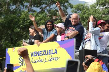La presidenta encargada de Venezuela, Delcy Rodríguez, saluda junto al ministro de Interior y Justicia, Diosdado Cabello, durante una caravana este jueves, en Caracas (Venezuela).