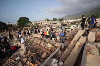 Personas realizan labores de búsqueda en una zona afectada por los terremotos en Venezuela.