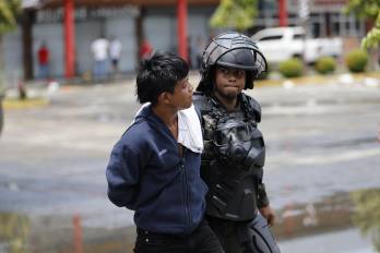 Un integrante de las Fuerzas Armadas custodia a un manifestante durante una protesta este viernes en la ciudad de Changuinola.